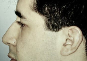 A man with a nose ring and a side view of his face.